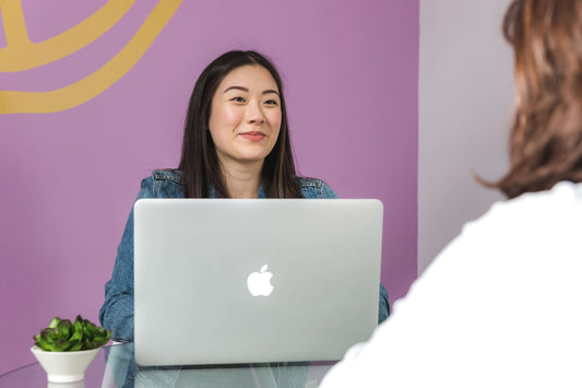 Image showing a business broker discussing documents with a client across a desk, representing guidance and support in facilitating a successful business sale.