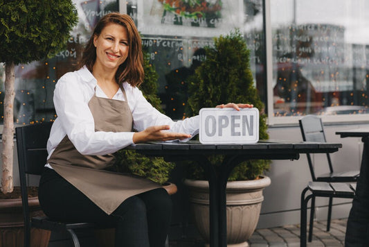 Cafe owner at storefront, showcasing world businesses for sale by owner