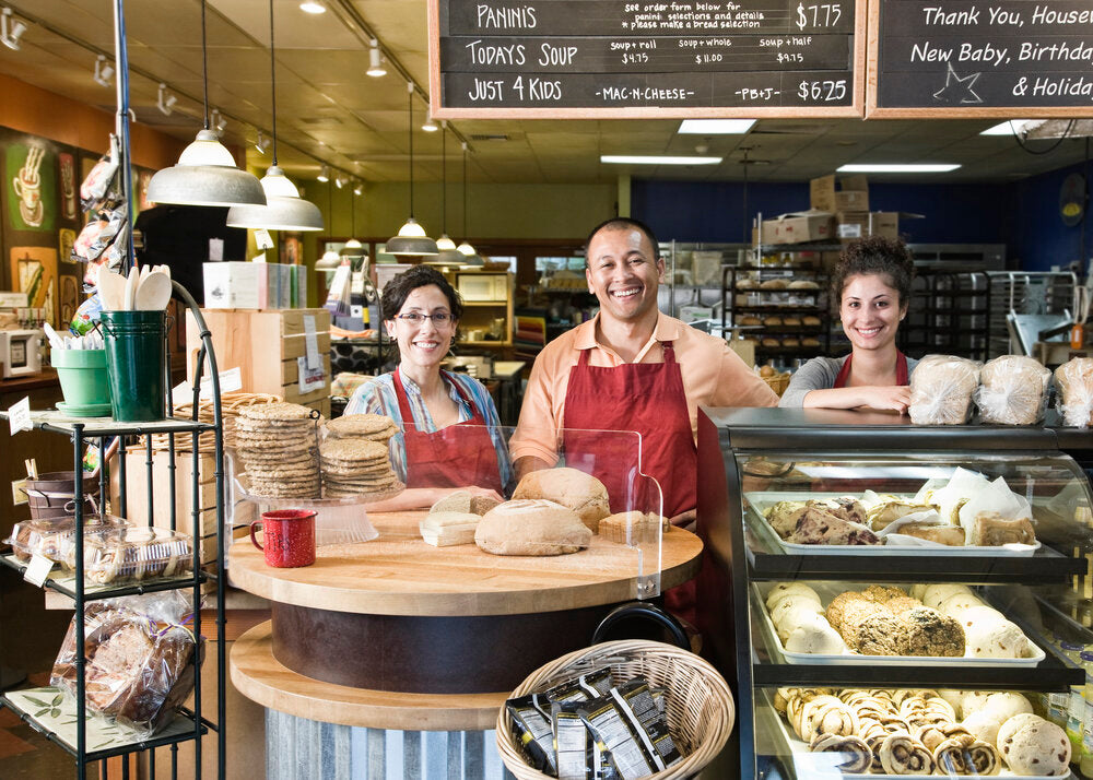Hispanic bakery owner and staff working together, representing a small business team — ideal example of businesses available for sale globally