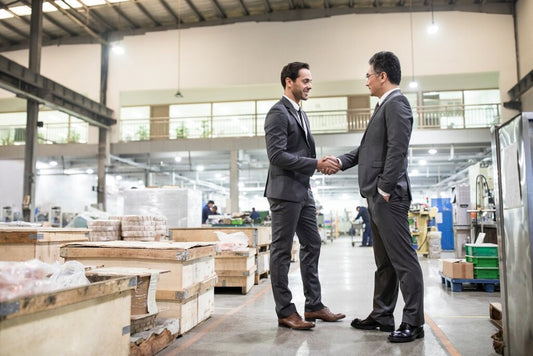 Two business professionals shaking hands after closing a successful business sale
