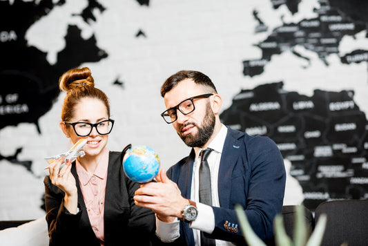 Smiling business couple discussing travel franchise options at a modern office — Explore global business opportunities to buy or sell now.