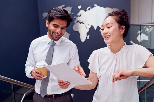 Two business owners reviewing listings to explore overseas businesses for sale