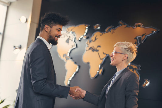 Two business people shaking hands, symbolizing buying and selling businesses worldwide.