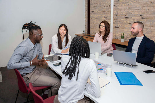 Business professionals using digital tools and documents to plan and manage business transactions at a modern office desk