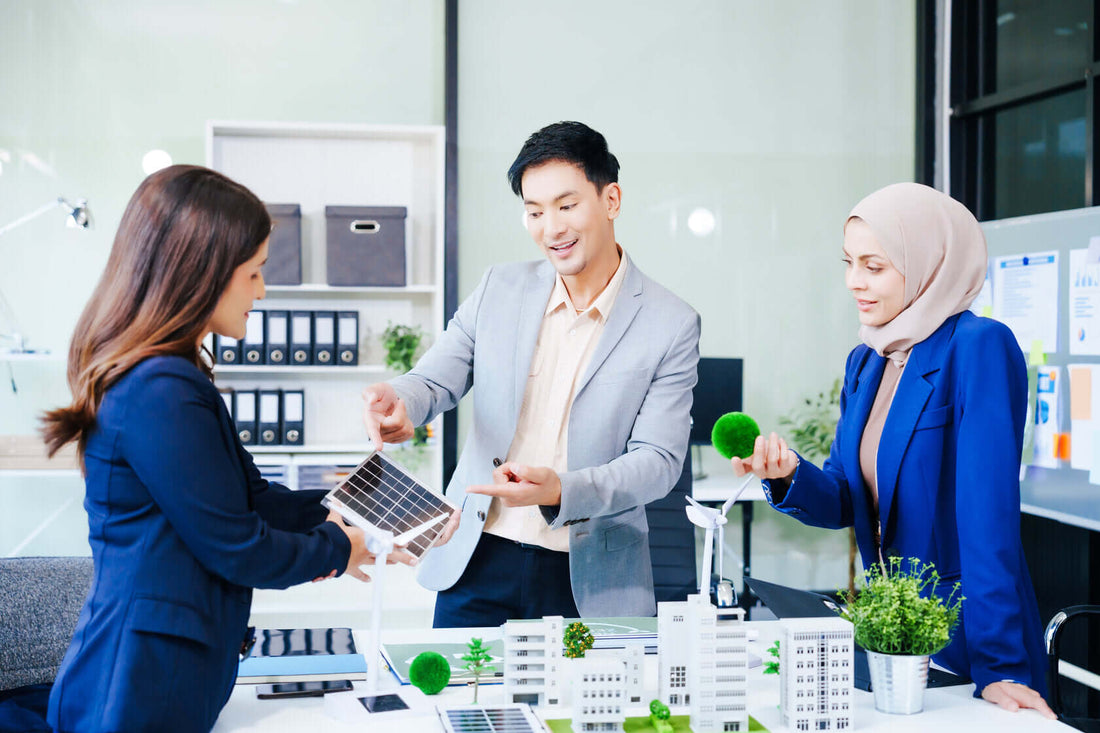 Trio of businesspeople, including a middle-aged Asian man and woman, collaborating and strategizing at their desk in an office setting