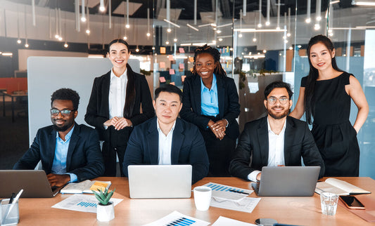 Diverse business team working in modern office discussing global business opportunities and companies for sale worldwide.