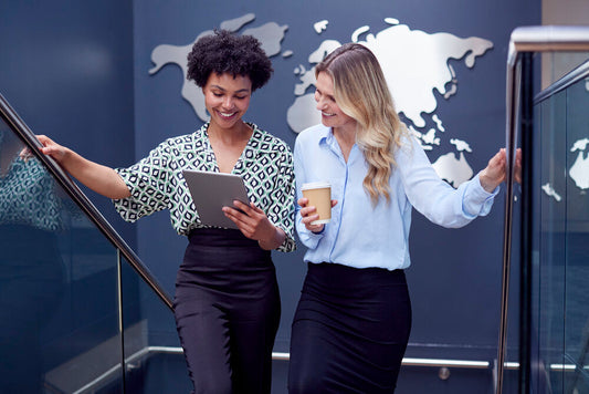 Female colleagues using a digital tablet in a meeting discussing mistakes to avoid when buying a world business