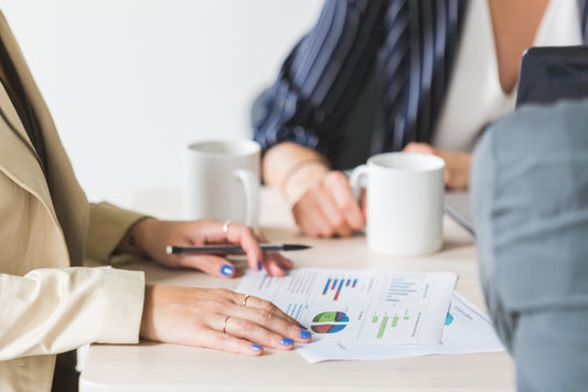 Image showing a business owner reviewing documents with a consultant, symbolizing the steps and strategies involved in successfully selling a business.