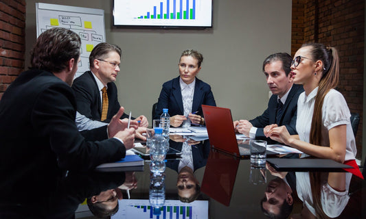 Business meeting between investors and company owner discussing profitable business sale.