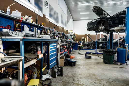 Automotive repair shop in Calgary, Canada with six service bays, modern diagnostic tools, and mechanics working on vehicles.