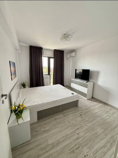 Modern bedroom with a bed, TV, and decor elements.