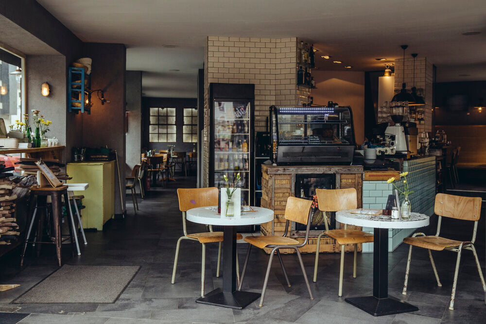 Interior of a cozy Berlin café & bistro with modern décor, seating for guests, and warm lighting.