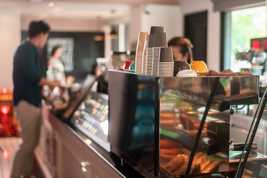 Cozy interior of a well-established London coffee shop with modern décor, seating area, and a counter displaying pastries and coffee equipment.