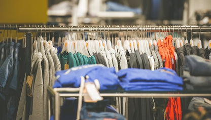 Interior of a clothing wholesaler in a prime Ottawa industrial park, showing neatly organized shelves and racks filled with various styles and colors of t-shirts.