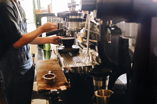 Interior of a Vancouver coffee roastery and café with espresso bar, seating area, and specialty coffee roasting equipment.