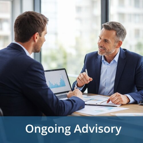 Ongoing business advisory meeting with experienced advisor reviewing performance and answering client questions